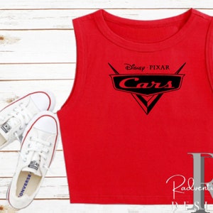 K&ouml;nnte beinhalten: Rotes &auml;rmelloses Crop-Top mit dem Disney Pixar Cars-Logo in Schwarz. Das Logo zeigt den Titel des Films Cars und ein stilisiertes Auto-Emblem.