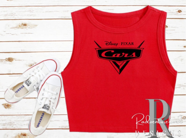 K&ouml;nnte beinhalten: Rotes &auml;rmelloses Crop-Top mit dem Disney Pixar Cars-Logo in Schwarz. Das Logo zeigt den Titel des Films Cars und ein stilisiertes Auto-Emblem.