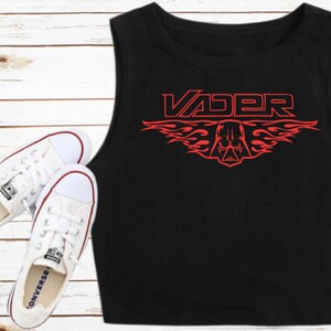K&ouml;nnte beinhalten: Schwarzes &auml;rmelloses Crop-Top mit einer roten Grafik von Darth Vaders Helm mit Flammen und dem Wort "VADER" dar&uuml;ber.