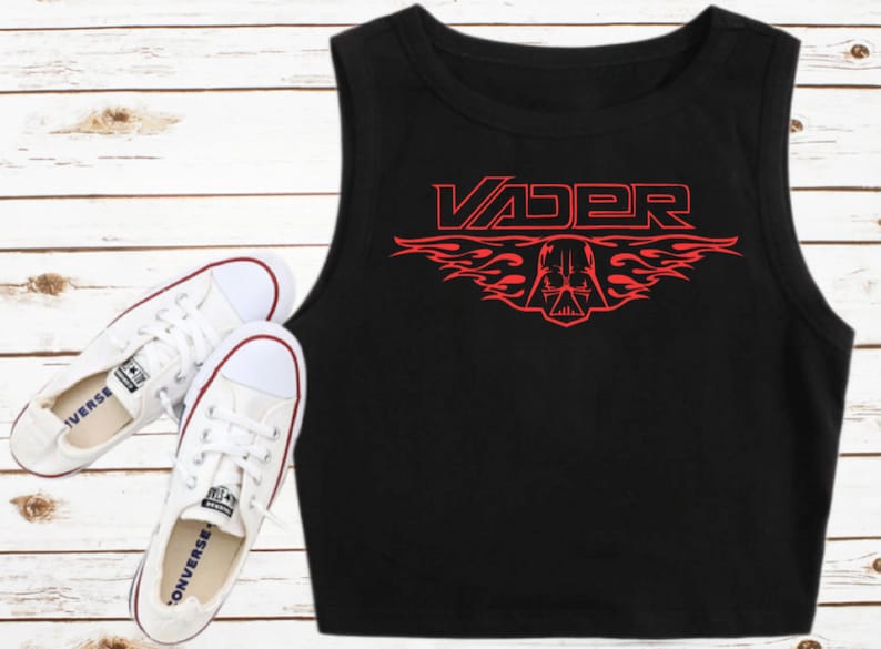 K&ouml;nnte beinhalten: Schwarzes &auml;rmelloses Crop-Top mit einer roten Grafik von Darth Vaders Helm mit Flammen und dem Wort "VADER" dar&uuml;ber.