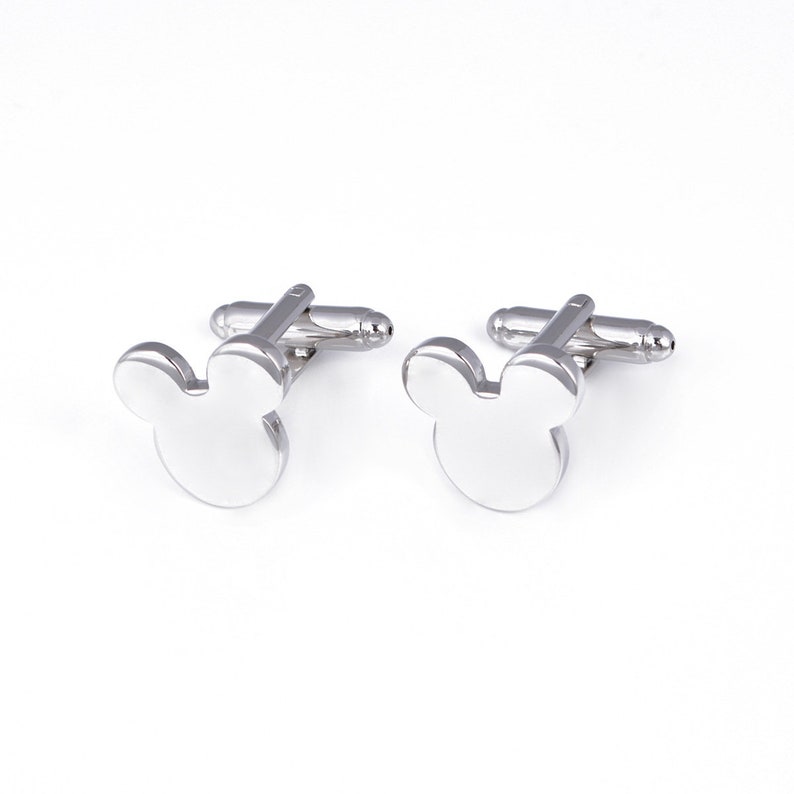 May include: A pair of silver cufflinks with a Mickey Mouse head design.