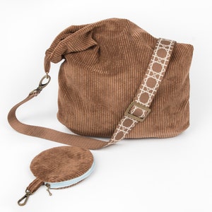 May include: A brown corduroy shoulder bag with a light blue and white patterned strap and a matching brown corduroy coin purse.