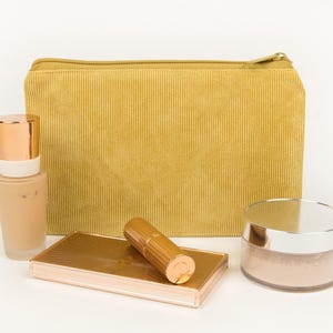 May include: A set of three ceramic mugs with a speckled, matte finish. The mugs are in shades of cream, light grey, and dark grey. Each mug has a simple, minimalist design, ideal for coffee or tea.