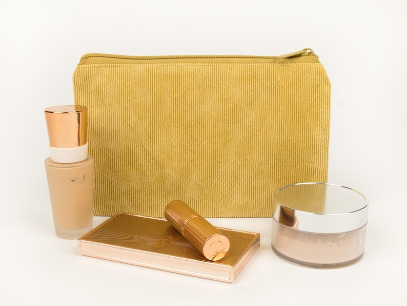 May include: A set of three ceramic mugs with a speckled, matte finish. The mugs are in shades of cream, light grey, and dark grey. Each mug has a simple, minimalist design, ideal for coffee or tea.