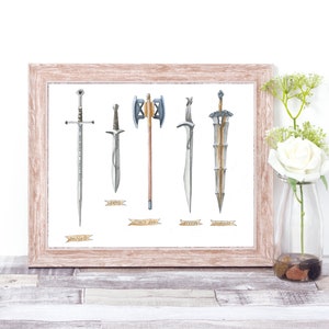 May include: A framed print featuring watercolor illustrations of five different swords and axes. The weapons are displayed against a white background, with a light brown wooden frame. Each weapon has a name written below it on a banner.
