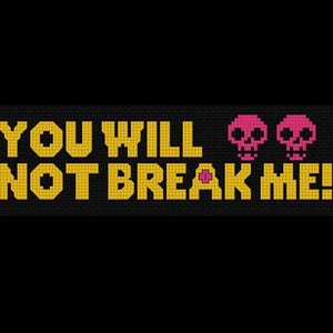 May include: Black cross-stitch design with the text "YOU WILL NOT BREAK ME!" in gold, accompanied by two pink skull graphics. The design has a pixelated appearance, typical of cross-stitch.