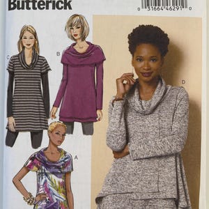 May include: Butterick sewing pattern B6247 for a cowl neck tunic with long sleeves. The envelope displays four variations: a striped version, a solid purple version, a floral print version, and a heathered gray version with a layered hem.