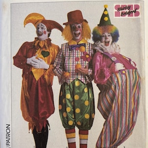 May include: A Simplicity sewing pattern envelope for three clown costumes. The image shows three individuals in colorful clown outfits, including a jester-style suit, a plaid vest with polka-dot pants, and a striped jumpsuit with a ruffled collar.