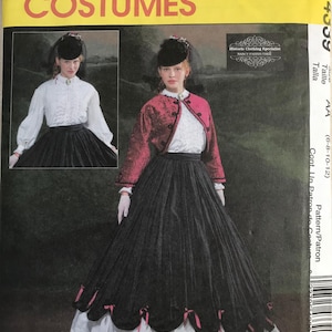 May include: A McCall's Costumes sewing pattern envelope, number 4339, featuring a historical-style outfit. The design includes a white ruffled blouse, a dark red textured jacket with black trim, and a long black skirt with pink ribbon accents.