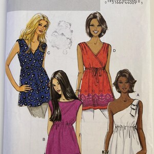 May include: A Butterick B5644 sewing pattern envelope featuring illustrations of four sleeveless tops. Designs include a blue leopard print wrap top, a red patterned wrap top with a tie waist, a solid magenta top, and a white one-shoulder top.