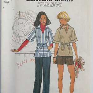 May include: A white ceramic mug with a black handle and the text "But First, Coffee" in a black, bold font. The mug is on a white surface. The mug is likely for hot beverages.