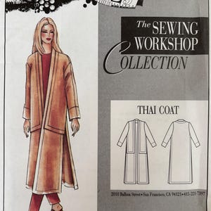 May include: A sewing pattern envelope for The Sewing Workshop Collection Thai Coat. The front features an illustration of a long, tan, open-front coat worn over a dark red top and pants, with line drawings showing front and back views of the coat.