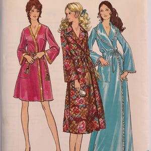 May include: A Butterick sewing pattern envelope 5997 for size 16 and bust 38. The illustration shows three robe styles: a short pink robe with gold trim, a mid-length floral print robe with a belt, and a long light blue robe with lace trim.