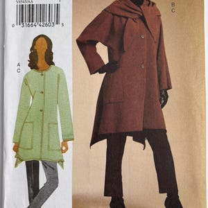 May include: V8545 sewing pattern featuring a woman in a brown coat with a hood and black pants. The pattern includes sizes AA (6-8-10-12). The Vogue Woman logo is at the bottom.