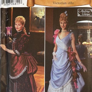 May include: Simplicity Historic Costumes pattern 5457 for Victorian 1880 attire. The package displays two dress variations: a dark red and black patterned gown with fringe trim, and a light blue gown with a white lace underskirt and floral accents.