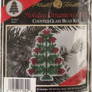 May include: A Mill Hill Holiday Ornaments IV Counted Glass Bead Kit featuring a H44 Feather Tree design. The packaging displays a finished beaded Christmas tree ornament made with red and green glass beads on white perforated paper.