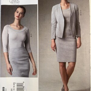 May include: A Donna Karan Collection Vogue Patterns sewing pattern envelope labeled V1389. The front displays two views of a light gray ensemble featuring a fitted skirt, a scoop-neck top with three-quarter sleeves, and a textured open-front blazer.