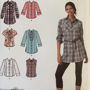 May include: Simplicity easy-to-sew pattern 2447. The image shows a woman wearing a plaid shirt and leggings. The pattern includes shirt designs with various styles, including a ruffled front and a sleeveless option. The pattern sizes are U5 16,18,20,22,24.
