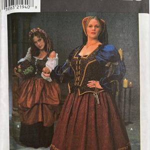 May include: A Simplicity Costumes sewing pattern envelope 8249 featuring two historical-style outfits. One outfit includes a dark bodice with gold trim, blue sleeves, and a long red skirt. The other features a white blouse, dark vest, and skirt.