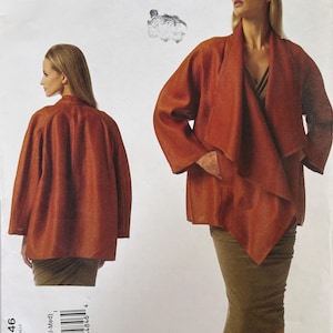 May include: A Donna Karan Collection Vogue Patterns American Designer sewing pattern envelope for a jacket, labeled V1346. The front shows a rust-colored jacket with a draped front and long sleeves, displayed from both the front and back views.