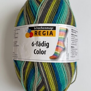 May include: A ball of Regia 6-fädig Color yarn in shades of teal, green, gray, and blue. The label shows a colorful sock design. The yarn is 375 meters or 410 yards.