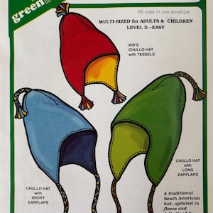 May include: A sewing pattern envelope for The Green Pepper Inc. F879 Fleece Chullo Hat. The illustration displays three hats in red, blue, and green, each featuring earflaps and braided tassels. Text includes Multi-sized for adults and children.