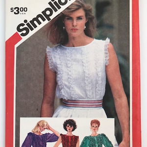 May include: A Simplicity sewing pattern envelope 5941 for a size 14 miss blouse. The cover features a white sleeveless blouse with vertical ruffles and a striped waistband. Illustrations show variations with long sleeves in purple, red, and green.
