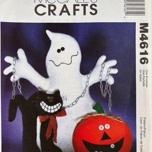 May include: A McCall's Crafts M4616 sewing pattern envelope featuring a white ghost, a black cat with a red bow, and an orange pumpkin with a wide grin. The characters are connected by silver-colored chains against a dark purple background.