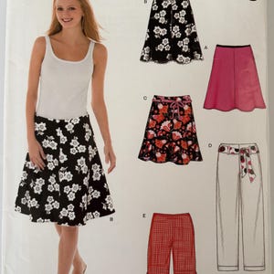 May include: A New Look sewing pattern featuring a woman wearing a white tank top and a black skirt with white floral designs. The pattern includes illustrations of various skirt and pants styles, with the text "NEW LOOK" and "easy".