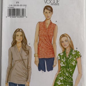 May include: A Vogue Patterns sewing pattern envelope V8790 for sizes 16-18-20-22-24. The front displays illustrations of three wrap-style tops: a sleeveless orange floral top, a short-sleeved green clover print top, and a long-sleeved solid beige top.