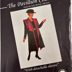 May include: A black coat with a patterned lapel featuring pink, purple, and red geometric designs. The text reads The Pavillion Coat From the Judy Bishop Collection and With detachable sleeves! The coat is worn with a black hat.