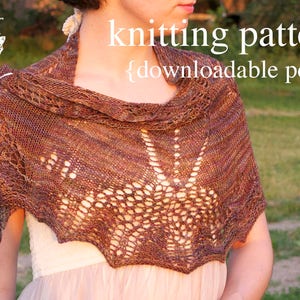 May include: A brown and beige knitted shawl with a lacy pattern. The shawl is draped over a person's shoulders. The text "knitting pattern {downloadable pdf}" is superimposed on the image.