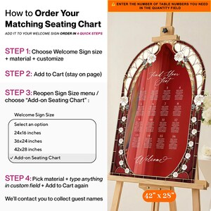 May include: A wedding seating chart displayed on an easel. The chart is a stained-glass design with a red background, white roses, and the words "Find Your Seat" and "Welcome." The chart measures 42 x 28 inches.