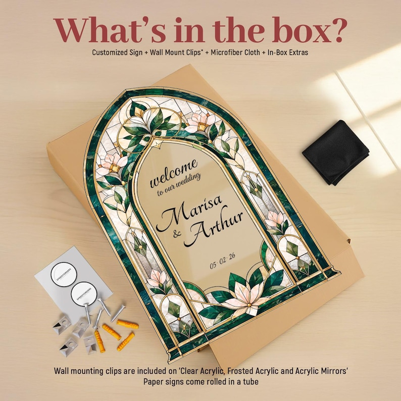 May include: An arched wedding sign featuring a stained glass-style border with green leaves and pink flowers. The center text reads welcome to our wedding Marisa & Arthur 05-02-26. Included are wall mount clips, a microfiber cloth, and in-box extras.