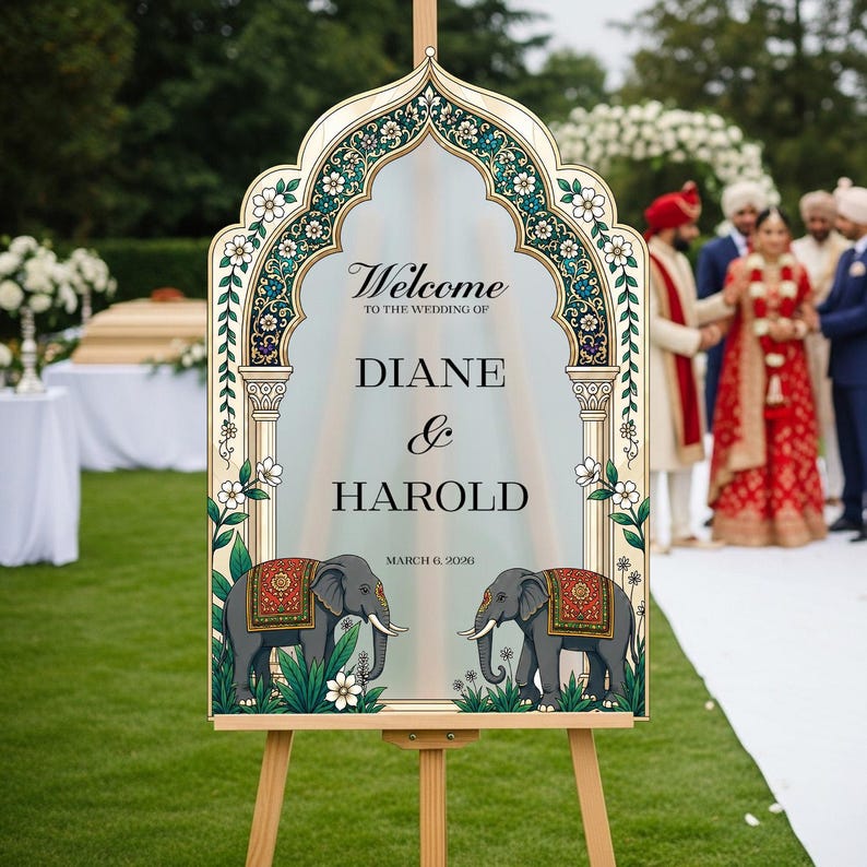Peut inclure: Un panneau de bienvenue de mariage avec un cadre en arche orn&eacute; de motifs floraux, deux &eacute;l&eacute;phants avec des couvertures d&eacute;coratives et le texte : Welcome to the wedding of Diane & Harold, March 6, 2026. Le panneau est sur un chevalet en bois.