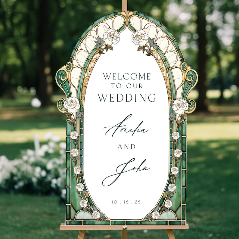 May include: An arched wedding welcome sign featuring a stained glass-style border in shades of green and gold with white rose illustrations. The centre text reads: WELCOME TO OUR WEDDING, Amelia AND John, 10.15.25. The sign is mounted on a wooden easel.