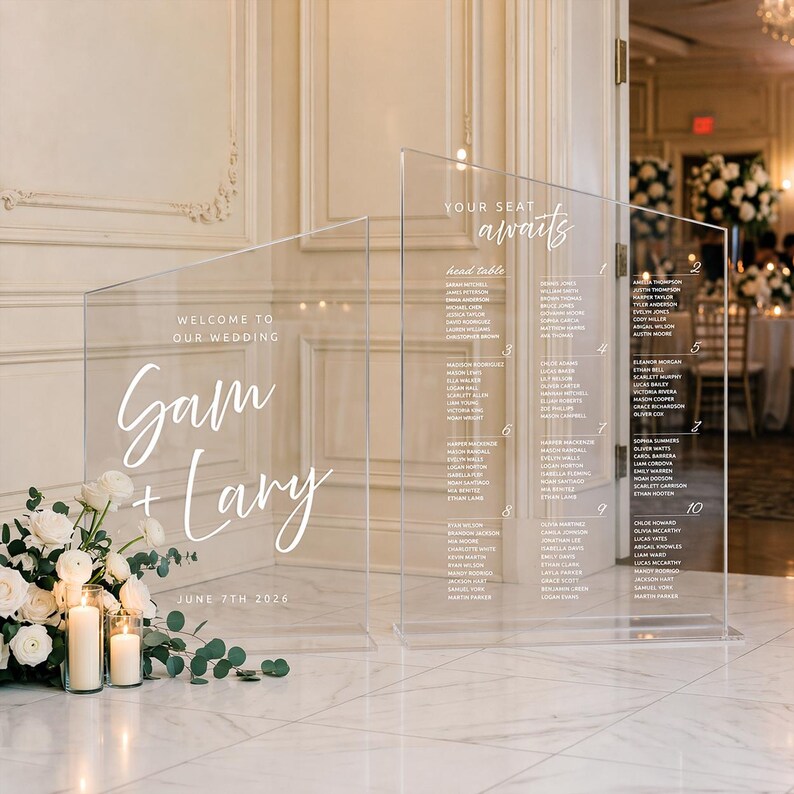 K&ouml;nnte beinhalten: Transparente Tischplan-Tafel f&uuml;r Hochzeiten aus Acryl mit wei&szlig;er Schrift. Der Text lautet "Welcome to Our Wedding" und "Sam + Lary" mit dem Datum "June 7th 2026". Die rechte Tafel listet die Namen der G&auml;ste auf. Ein Blumenarrangement und Kerzen befinden sich im Vordergrund.
