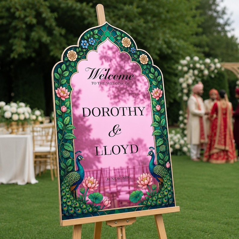 Op de afbeelding: Een boogvormig welkomstbord voor een bruiloft met een roze middenstuk en de tekst Welcome to the wedding of Dorothy & Lloyd June 6, 2026. De rand is versierd met groene pauwillustraties, lotusbloemen en blauwe en gele bloemaccenten.