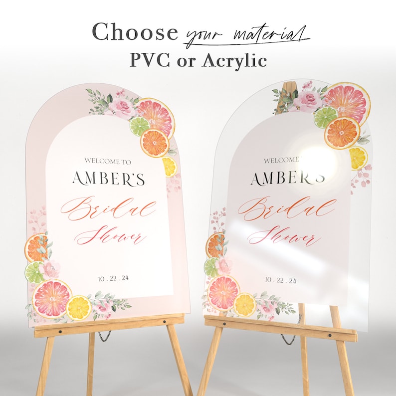 May include: Two welcome signs for a bridal shower with a pink and white background and a citrus fruit design. The text on the signs reads "Welcome to Amber's Bridal Shower 10.22.24".