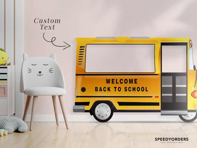 May include: A yellow school bus wall decal with the words "Welcome Back to School" on the side. The decal is on a pink wall with a white chair in front of it.