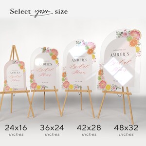 May include: Four clear acrylic signs with a rounded arch top, featuring a watercolour design of citrus fruit and flowers. The signs are on wooden easels and have the text "Welcome to Amber's Bridal Shower" with different sizes listed below each sign: 24x16 inches, 36x24 inches, 42x28 inches, and 48x32 inches.