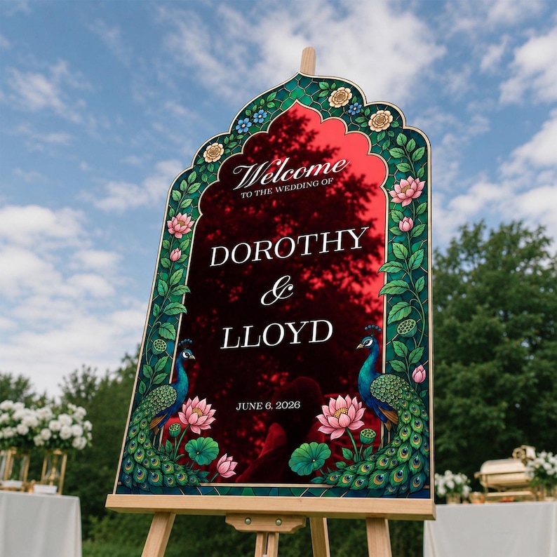 Op de afbeelding: Een boogvormig welkomstbord voor een bruiloft met een reflecterend rood oppervlak en witte tekst die luidt Welcome to the wedding of Dorothy & Lloyd June 6, 2026. De rand is versierd met groene pauwenillustraties en roze lotusbloemen.