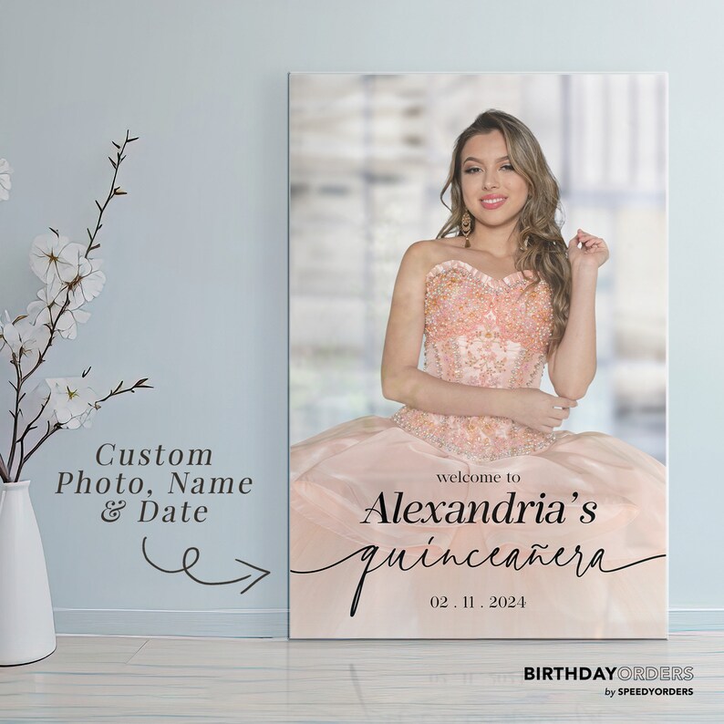 May include: A welcome sign for a quincea&ntilde;era, featuring a photo of the birthday girl in a pink dress. The sign says "Welcome to Alexandria's Quincea&ntilde;era" with the date "02.11.2024".