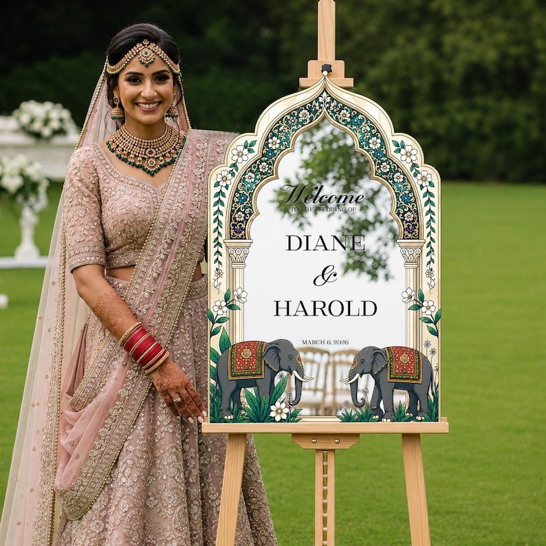 Peut inclure: Un panneau de bienvenue de mariage sur un chevalet en bois avec un cadre en arc orn&eacute; de motifs floraux verts et dor&eacute;s, le texte Welcome to the wedding of Diane & Harold, et deux &eacute;l&eacute;phants gris avec des couvertures rouges et dor&eacute;es, dat&eacute; du 6 mars 2026.