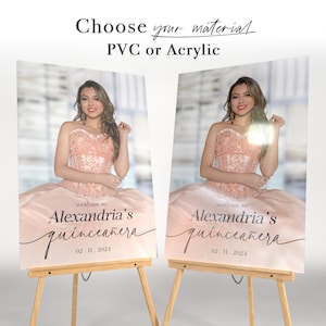 May include: Two welcome signs for a quincea&ntilde;era, featuring a photo of the quincea&ntilde;era in a pink dress. The signs are printed on a pink background with the text "Welcome to Alexandria's Quincea&ntilde;era" and the date "02.11.2024".
