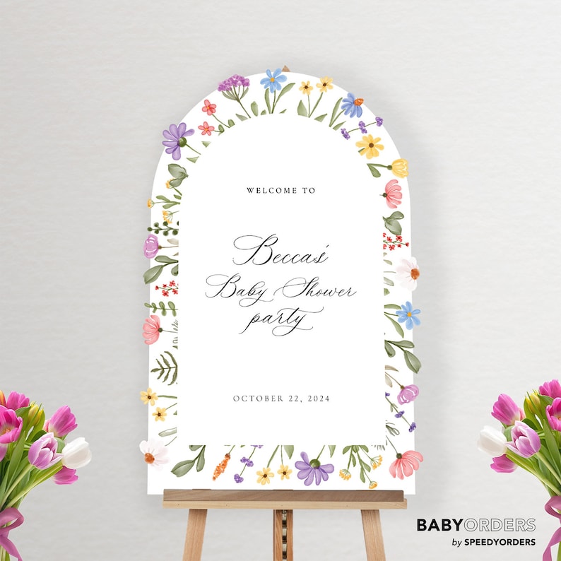 May include: An arched white welcome sign for a baby shower featuring watercolor floral illustrations along the border. The text reads Welcome to Becca's Baby Shower party October 22, 2024. The sign is displayed on a wooden easel with bouquets of tulips.