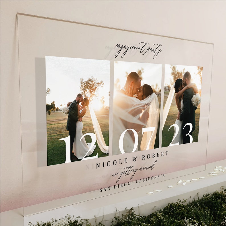 K&ouml;nnte beinhalten: Ein rechteckiges Schild aus klarem Acryl mit drei vertikalen Fotopaneelen eines Paares. Der Text lautet engagement party, 12 07 23, NICOLE & ROBERT are getting married und SAN DIEGO, CALIFORNIA. Das Design enth&auml;lt einen sanften Farbverlauf.
