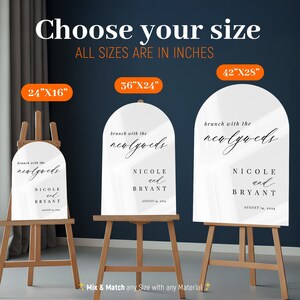 May include: Three arched white signs on wooden easels with the text brunch with the newlyweds, Nicole and Bryant, August 14, 2024. Sizes are labeled as 24 inches by 16 inches, 36 inches by 24 inches, and 42 inches by 28 inches in orange boxes.