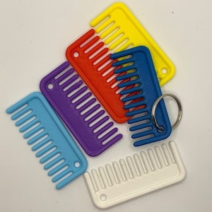 May include: Five colourful plastic combs, each with a different colour: yellow, red, purple, blue and white. The combs are all the same size and shape, and they have a key ring attached to the blue comb.