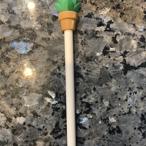 May include: A white Apple Pencil with a green succulent plant topper. The succulent is in a brown pot.